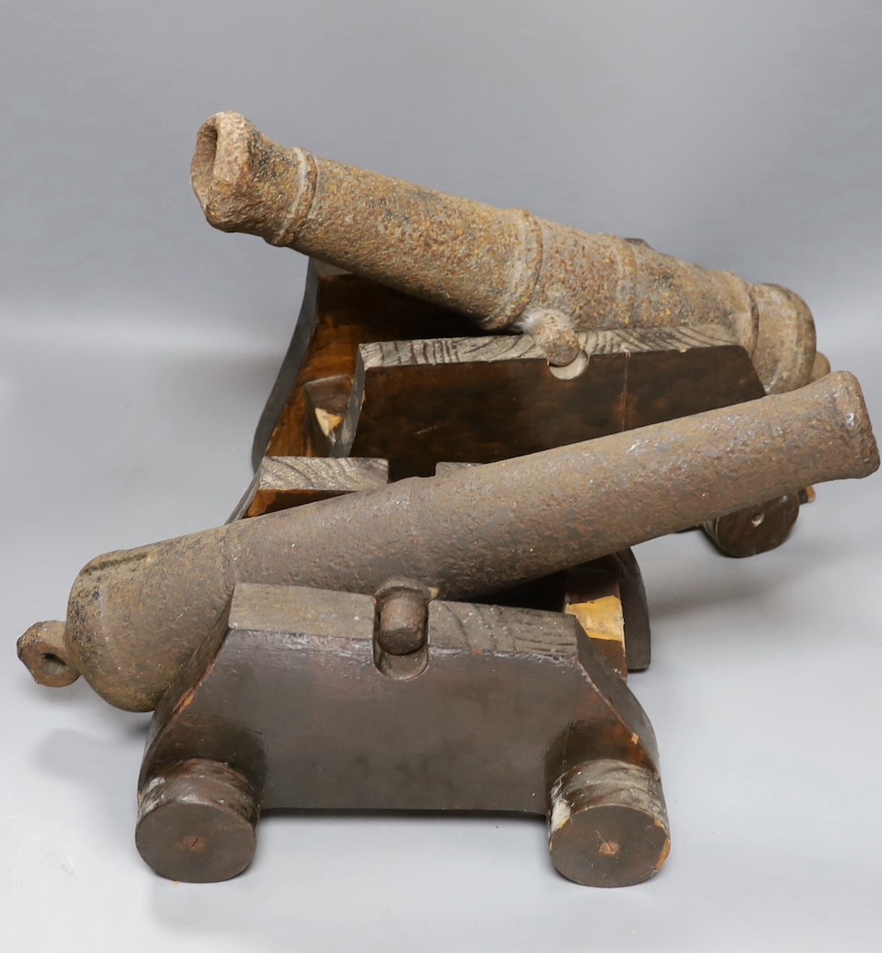 Two 19th century cast iron small cannon, on later wheeled carriages and related diagrams, largest 43 cms long.